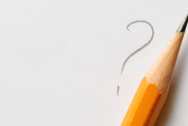 istock Pencil next to question mark on white paper 1158473471