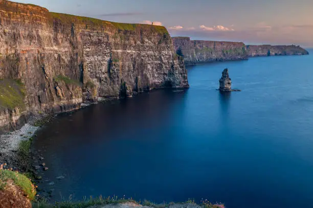 Photo of The stunning and majestic Cliffs of Moher in County Clare, Ireland at sunset, beautiful pink sky taken from Luca Lookout