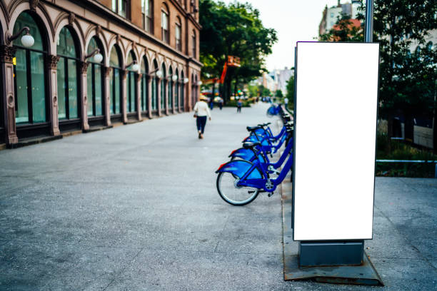 istock Paid bicycle station with rows for parking supplying eco friendly transport in metropolis, small clear billboard near rental cycles on square in downtown with blank copy space area for advertising 1158480213