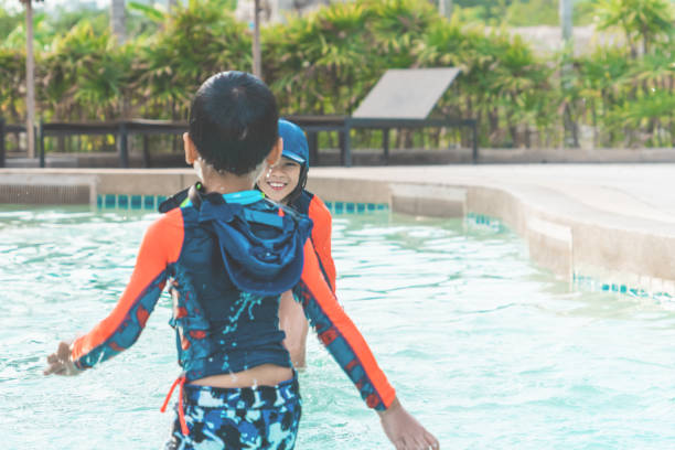 istock Two Asian siblings in playing together in Water Aqua park pool. 1158480267