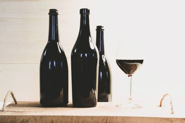 istock Black bottles and red wineglass on the table 1158480355