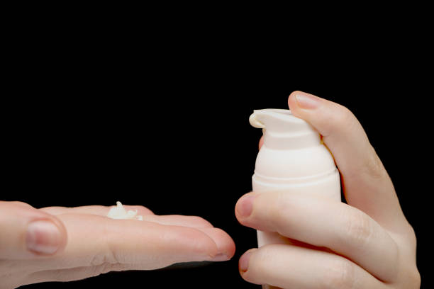istock Woman hands with cream, isolated on black 1158480422