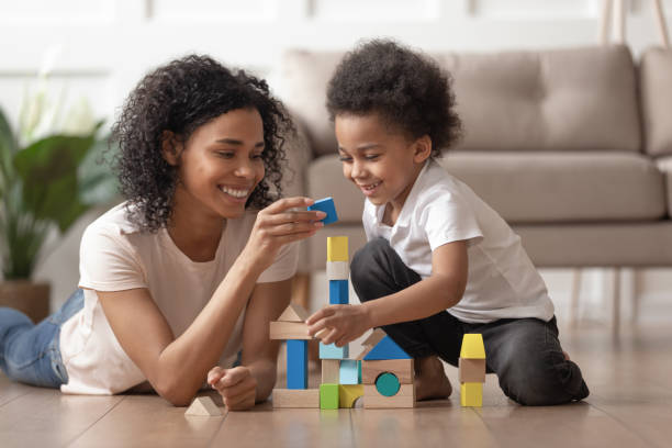 madre africana con figlio piccolo gioca con blocchi di legno - block togetherness happiness indoors foto e immagini stock