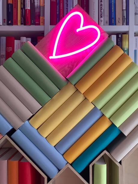 Books shelves packed with generic colorful books and neon heart shape