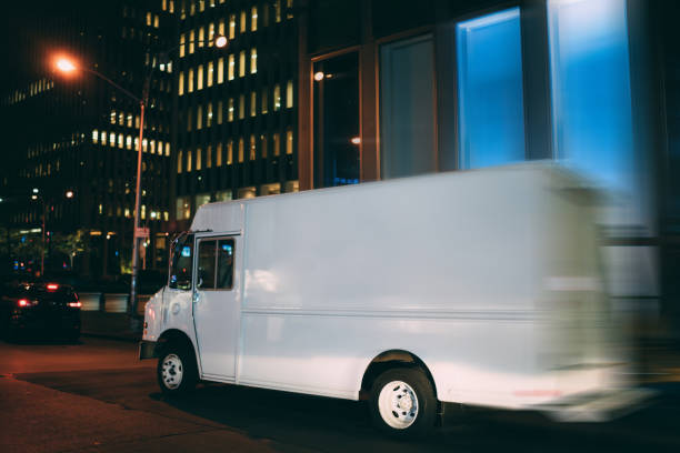 istock Van automobile driving fast in evening downtown transporting and distributing goods for delivery service, mock up copy space on cargo body for logistic company name or logo of startup business 1158482120