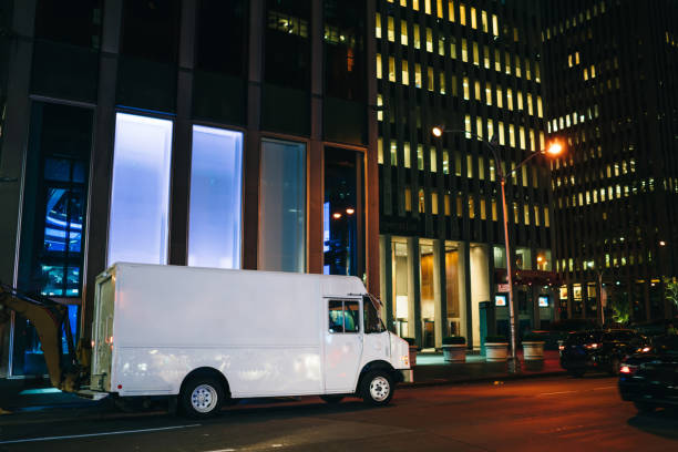istock White van automobile delivery and transporting good for logistic service driving on road in evening megalopolis, blank truck body with copy space area for advertising or commerce information on street 1158482131