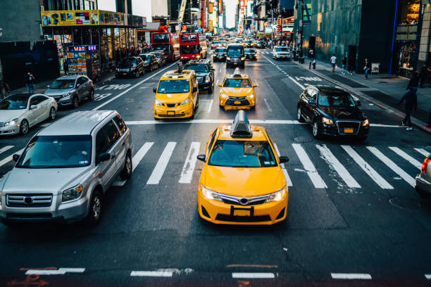 맨해튼의 도로를 지나가는 노란 택시는 낮에는 건물과 상업도로를 지나며, 뉴욕 다운타운의 도로에서 자동차와 택시 택시가 도시 교차로 근처에서 정차하는 바쁜 교통 체증 - dusk people manhattan new york city 뉴스 사진 이미지