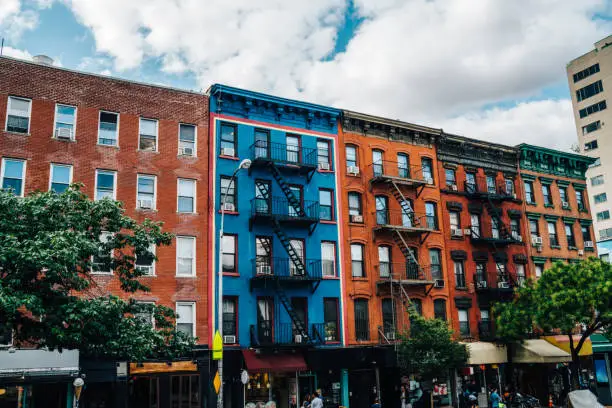 Beautiful cityscape of vintage colourful building with fire escape from residential flats and commercial real estate on ground floor,old houses in Brooklyn district with rental apartments for living