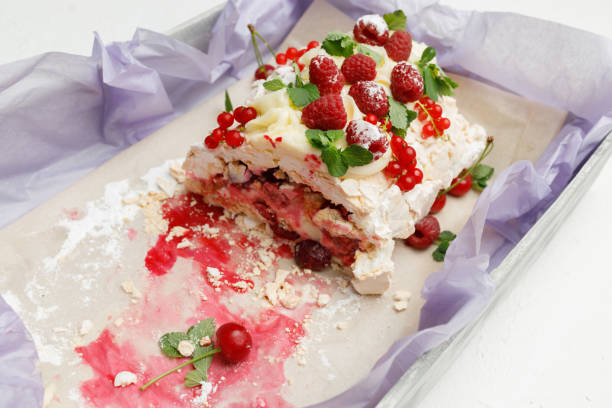 istock Delicate meringue pie with cherries, red currants and raspberries with mint leaves is on a tray 1158482621