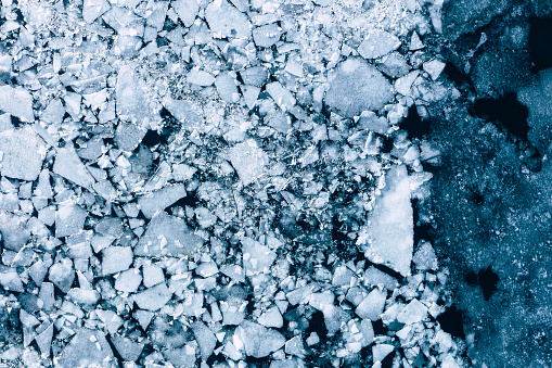 Glacier Lagoon with icebergs from above. Aerial View. Cracked Ice from drone view. Background texture concept.