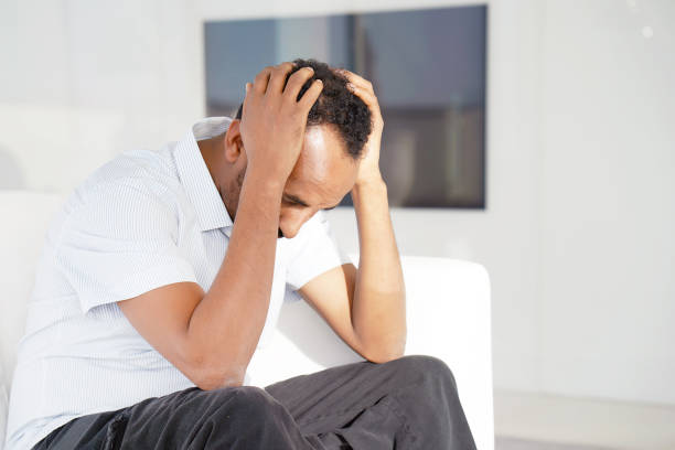 istock sad african man lies on the bed. 1158485734