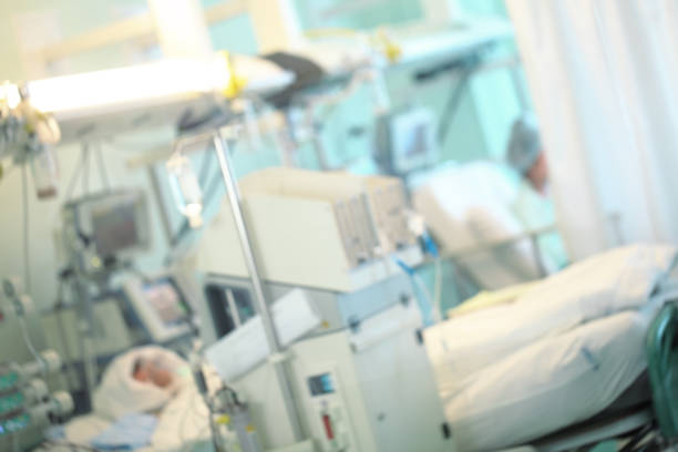 istock Patient in the intensive care unit surrounded by advanced life support equipment, unfocused background 1158485820