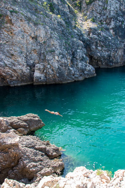istock Young woman diving headfirst into the sea 1158486946