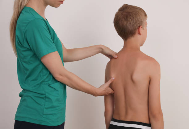 istock Child having chiropractic back adjustment. Osteopathy, Physiotherapy, Kinesiology. Bad posture correction 1158488544