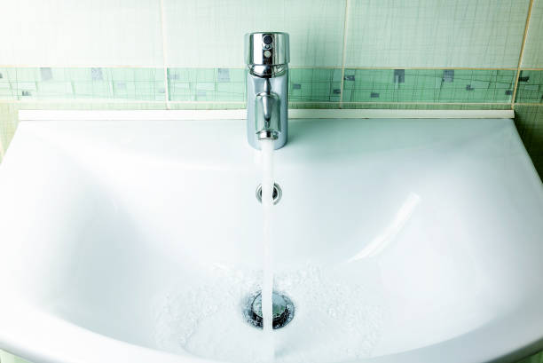 istock Water flows from the faucet into the sink. Concept saving water. 1158489519