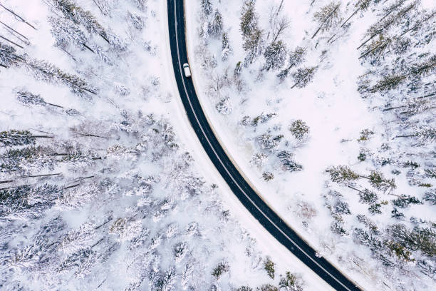 istock Curvy windy road in snow covered forest, top down aerial view. Winter landscape. 1158489628