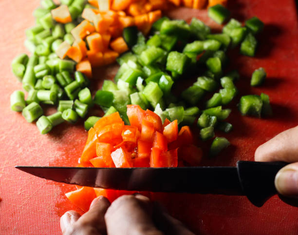 istock capsicum tomatoes and carrot cut into small pieces,finely chopped vegetables on a chopping board by knife in hand 1158491755
