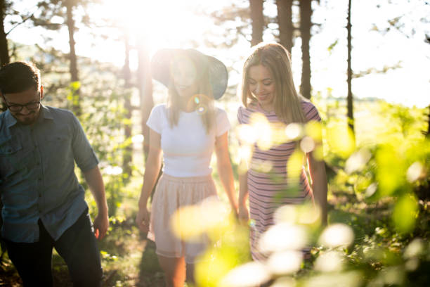 Three friends walking in the sunny spring woods and river