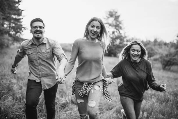 istock Three happy friends enjoying a sunset on a countryside. 1158495423
