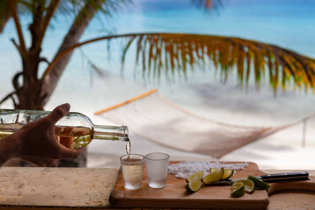 istock pouring tequilla with lime on a tropical beach in the caribbean 1158495438