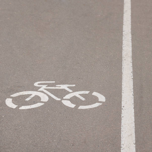 istock Closeup of a bicycle sign drawn on asphalt. Cycle path divided by a white line with a pedestrian road. 1158495706