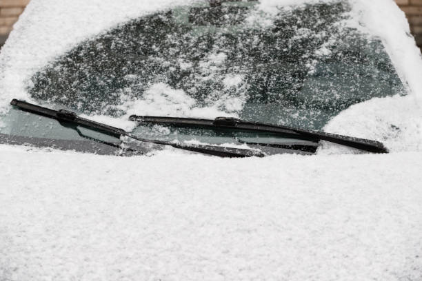 자동차 와이퍼 블레이드는 자동차 창문에서 눈을 제거합니다. 눈 조각은 두꺼운 층으로 차를 덮었다. 겨울, 얼음 차에 눈 덮인 날에 여행을 준비. 안전한 겨울 운전 - snow car window ice scraper 뉴스 사진 이미지