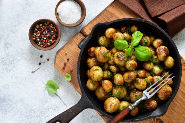 istock Fried, young potatoes with basil in a pan. View from above. 1158496407