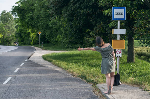 istock Young woman hitchhiking in bus stop 1158496431