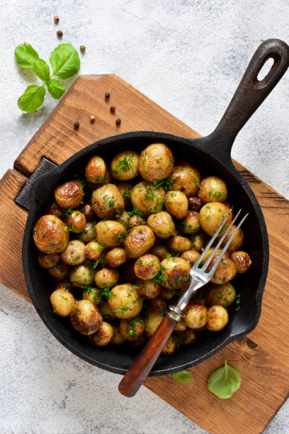 istock Fried, young potatoes with spices in a pan. View from above. 1158496445