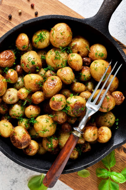 istock Fried, young potatoes with spices in a pan. View from above. 1158496450