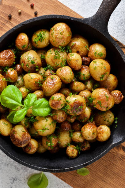 istock Fried, young potatoes with basil in a pan. View from above. 1158496466
