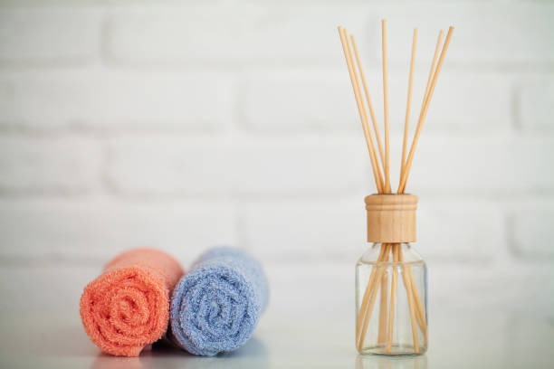 istock Fluffy bath towels on light wooden table with aroma sticks 1158498296