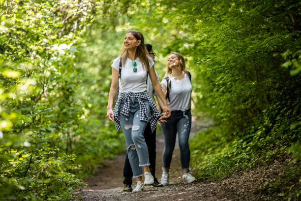 istock Three friends walking in the sunny spring woods and river 1158499754