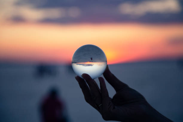 istock woman's hand with crystal ball Sunset 1158504438