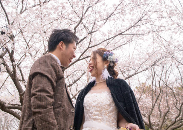 istock Bride and groom making a face under cherry blossoms 1158506929