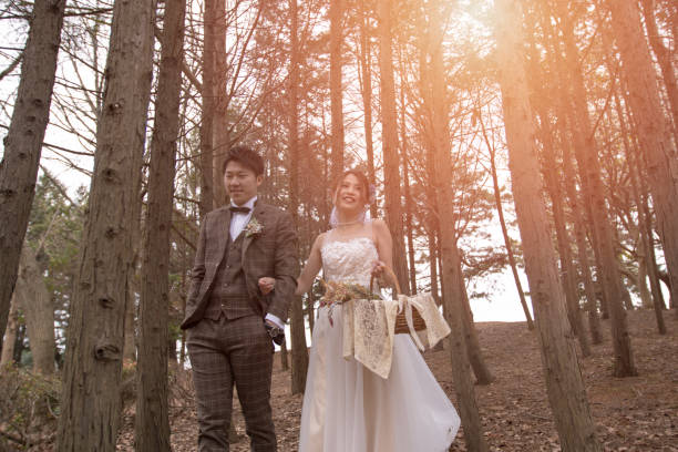 istock Happy bride and groom walking in forest 1158506965