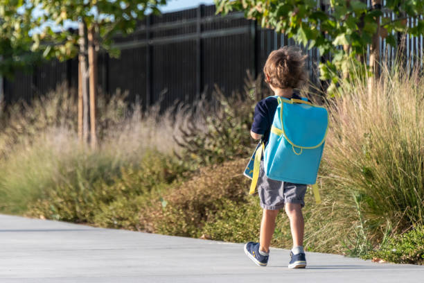 学校に戻って、小さな男の子が学校の最初の日に歩いて - little boys preschooler back to school backpack ストックフォトと画像