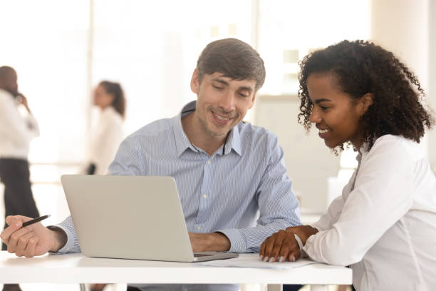 istock Diverse man and woman work using laptop in office together 1158514106
