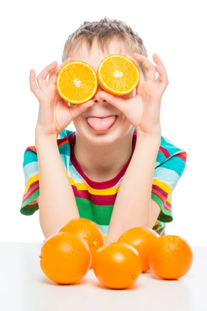 istock funny portrait of a boy with oranges on a white background 1158514190