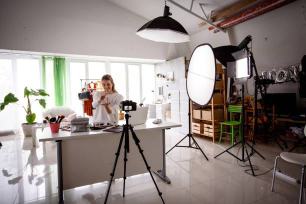 istock Young female vlogger in front of video camera at her studio 1158514221