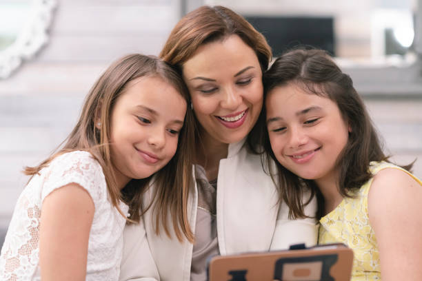 istock Mother and daughters take selfie picture on tablet computer 1158514512