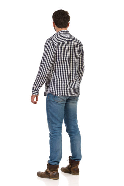 istock Standing Young Man In Boots, Jeans And Lumberjack Shirt. Rear Side View. 1158514595