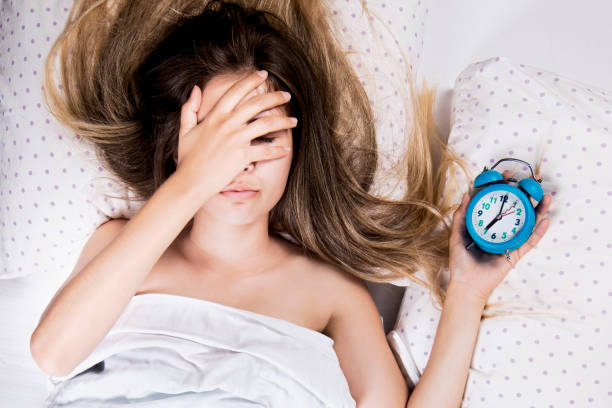 ragazza bionda dorme in un letto in camera da letto, sogna - women dependency business time foto e immagini stock