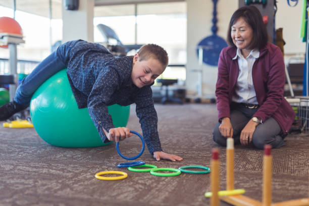 istock A boy does workouts with an occupational therapist at a physiotherapy clinic 1158514852