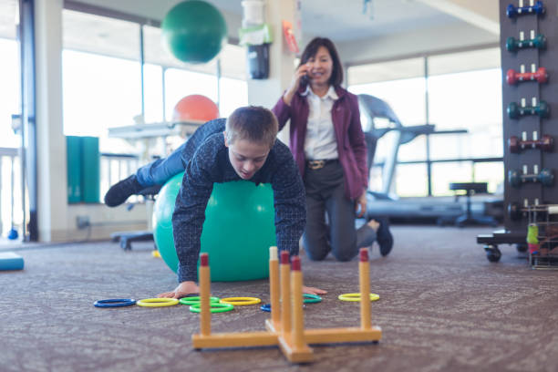 istock A boy does workouts with an occupational therapist at a physiotherapy clinic 1158514854