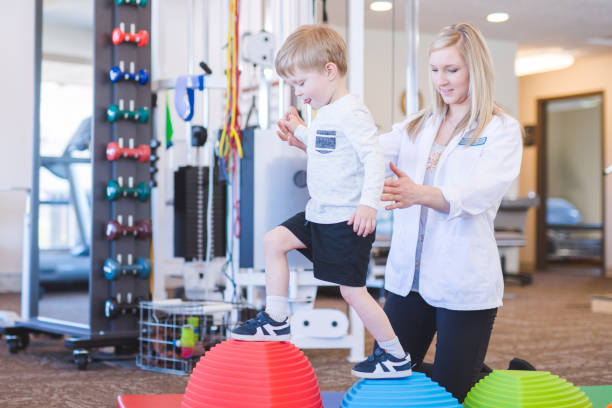 istock Physical therapist working with a young boy in the clinic 1158515859