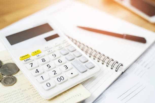 istock Office desk table calculator with notepad book, bank account and black pen. Top view with copy space. investment calculation Accounting, financial concept 1158518214