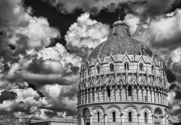 Pisa Baptistry medieval dome with clouds and city ancient walls