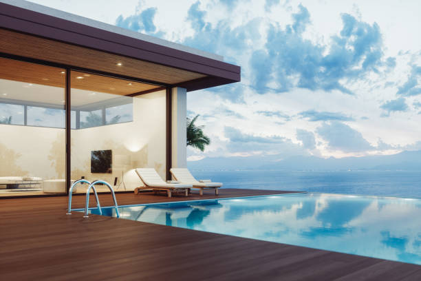 Modern Luxury House With Infinity Pool At Dawn Modern luxury villa exterior with infinity pool and beautiful ocean view at dawn. villa stock pictures, royalty-free photos & images