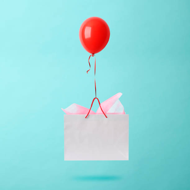 istock Flying red balloon with white shopping bag. 1158525156